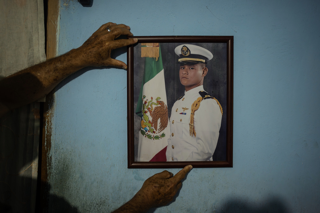 Eduardo Castillo shows a portrait of his son Lt. Luis Enrique Castillo, a victim of a Mexican Navy plane crash off the Texas coast, at the family house in El Pantano, Veracruz state, Mexico, Tuesday, Dec. 23, 2025. (AP Photo/Felix Marquez)