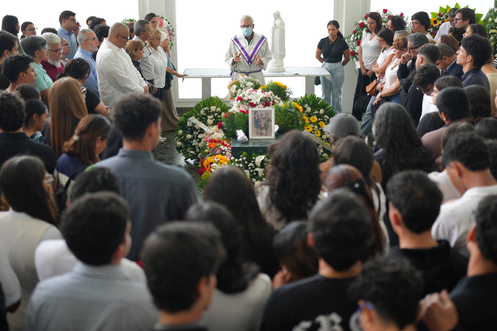 Relatives and friends attend the funeral Mass for Daniela Mora, her mother, Maria Cruz, and her grandmother, Judith Padron, who died when their apartment building collapsed during the earthquake in the San Bernardino neighborhood of Caracas, Venezuela, Saturday, July 4, 2026. (AP Photo/Matias Delacroix)