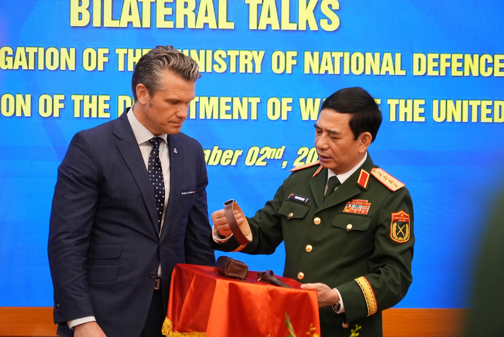 Vietnamese Defense Minister Phan Van Giang holds up a belt during an artifact exchange with U.S. Defense Secretary Pete Hegseth after their meetingin Hanoi, Vietnam, Sunday, Nov. 2, 2025. (AP Photo/Hau Dinh)