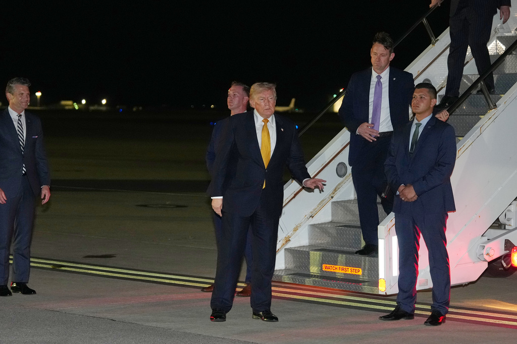 As Defense Secretary Pete Hegseth watches at left, President Donald Trump gestures as he switches planes at U.S. Air Force Base, RAF Mildenhall in Suffolk Eastern England, on his way back to Washington from the NATO summit in Ankara, Turkey, Wednesday, July 8, 2026. (AP Photo/Alex Brandon)