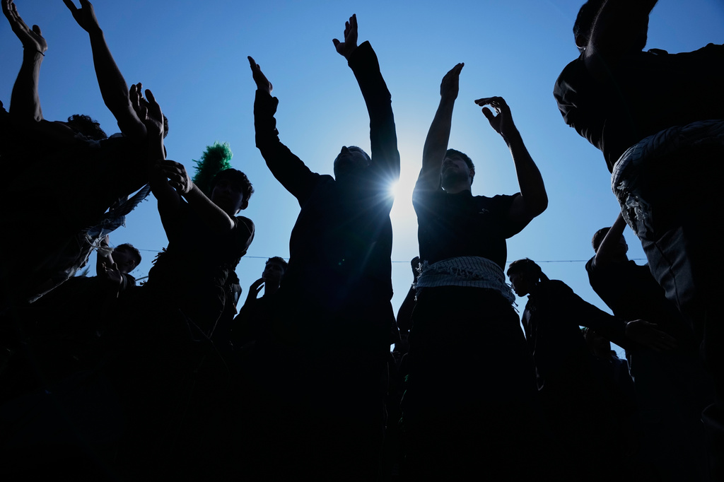 Shiite Muslim worshippers beat their chests in a ritual act of mourning as they march toward the Imam Hussein Shrine ahead of Arbaeen, the annual Shiite commemoration marking 40 days after Ashoura, in Karbala, Iraq, Monday, Aug. 3, 2026. (AP Photo/Hadi Mizban)