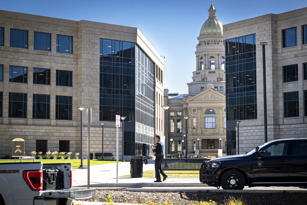 A Cheyenne Police Department officer sweeps the grounds of the Wyoming Capitol after a suspected improvised explosive device (IED) was found at the state Capitol on Tuesday, Oct. 21, 2025, in Cheyenne, Wyo. (Milo Gladstein/The Wyoming Tribune Eagle via AP)