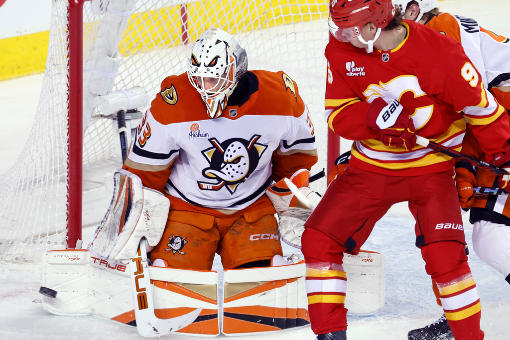 Anaheim Ducks goalie Ville Husso, left, makes a save as Calgary Flames' Victor Olofsson looks for a rebound during the first period of an NHL hockey game in Calgary, Alberta, Thursday, March 26, 2026. (Larry MacDougal/The Canadian Press via AP)