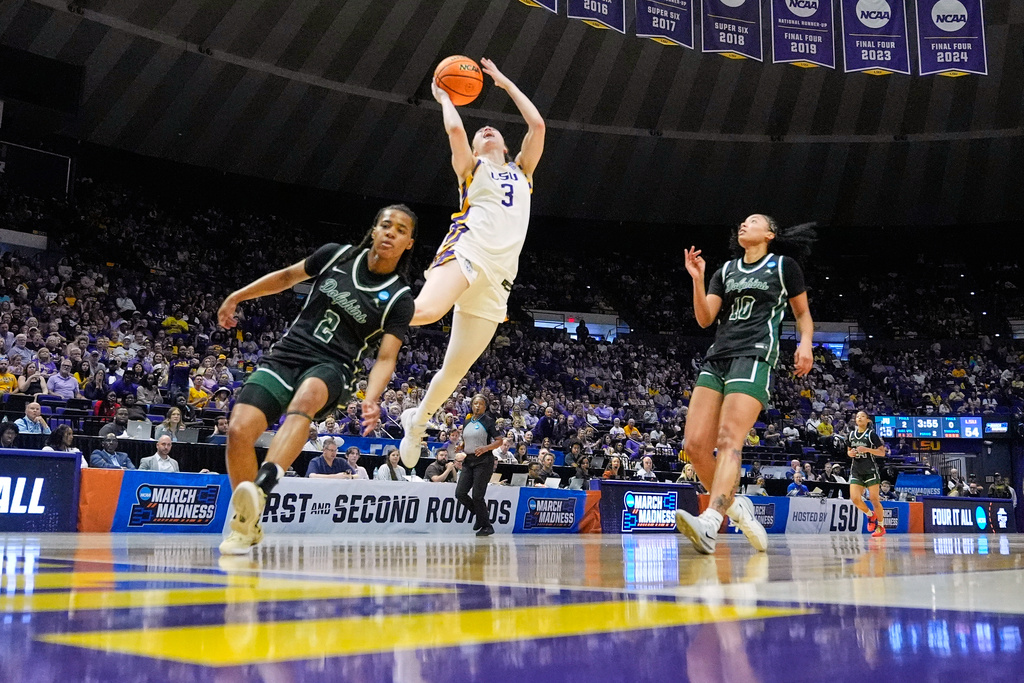 LSU guard Bella Hines (3) goes to the basket between Jacksonville guard Tatum Brown (2) and forward Carmaya Bowman (10) during the first half in the first round of the NCAA college basketball tournament, Friday, March 20, 2026, in Baton Rouge, La. (AP Photo/Gerald Herbert)