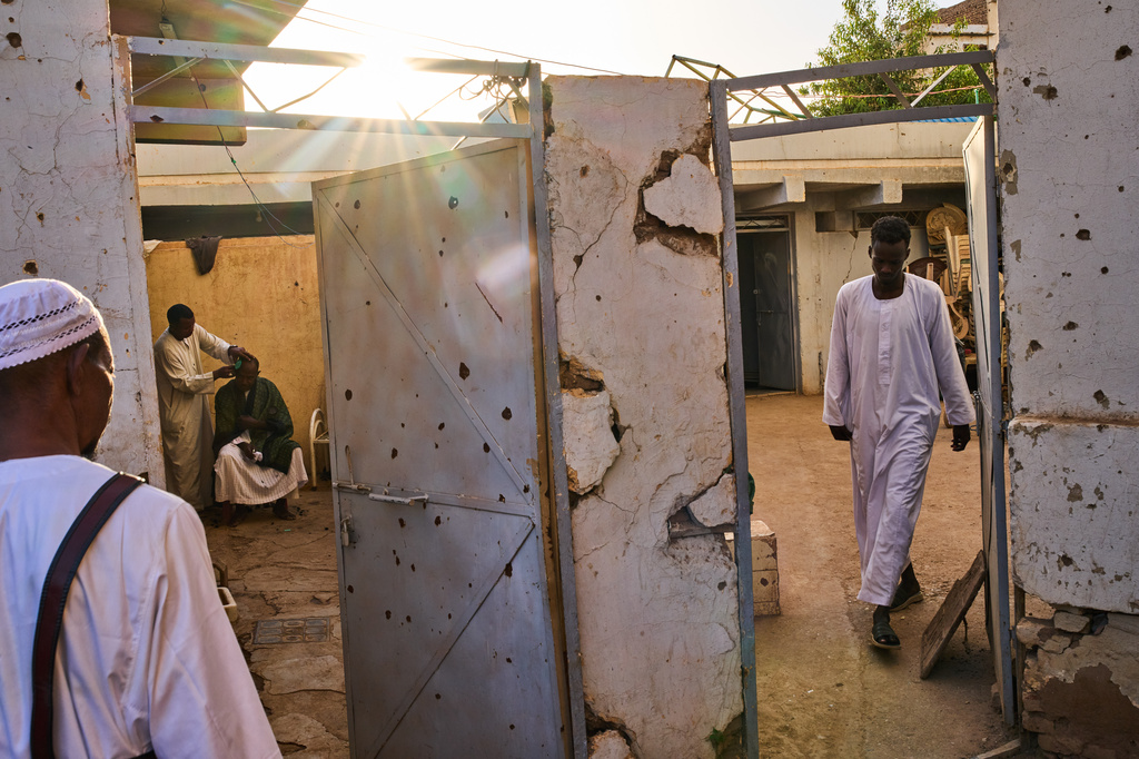 Sudanese men walk inside the war-damaged Sheikh GaribAllah Mosque in Omdurman, on the outskirts of Khartoum, Sudan, Friday, April 17, 2026. (AP Photo/Bernat Armangue)