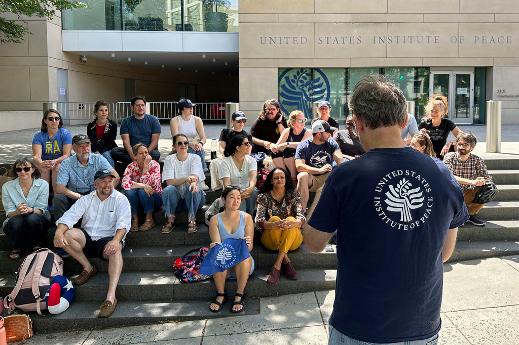 FILE - U.S. Institute of Peace employees hold an impromptu celebration on the steps of the U.S. Institute of Peace, May 19, 2025, in Washington. (AP Photo/Gary Fields, file)
