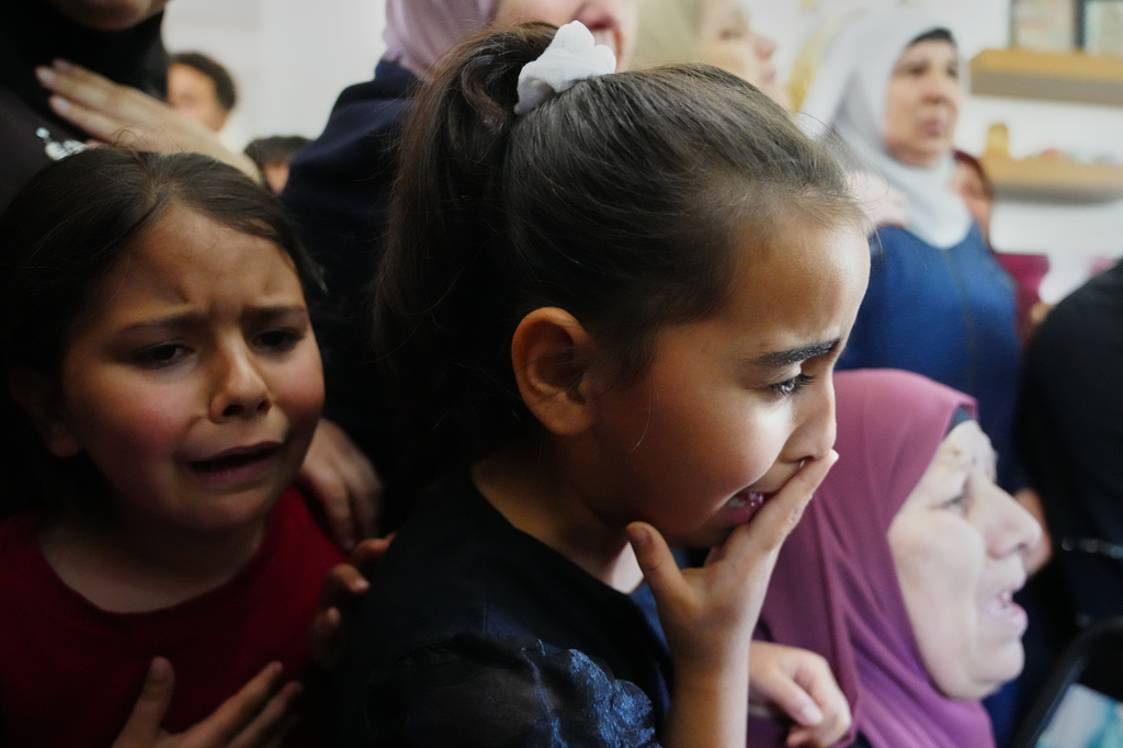 Children cry while they take the last look at the body of Palestinian Zakaria Qatousa, during his funeral in the West Bank town of Deir Qaddis Wednesday, May 13, 2026. (AP Photo/Mahmoud Illean)