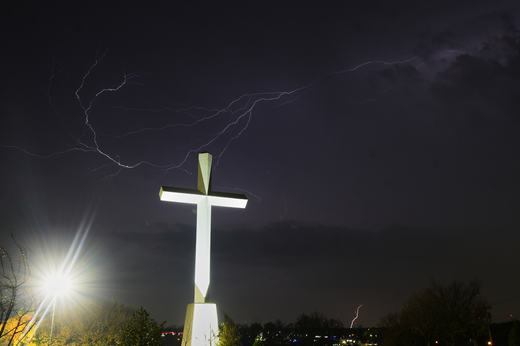 Lightning is visible on the sky near a large cross at the grounds of Life.Church, where Route 66 meets with Interstate-35 in Edmond, Okla, Wednesday, Nov. 19, 2025. (AP Photo/Julio Cortez)