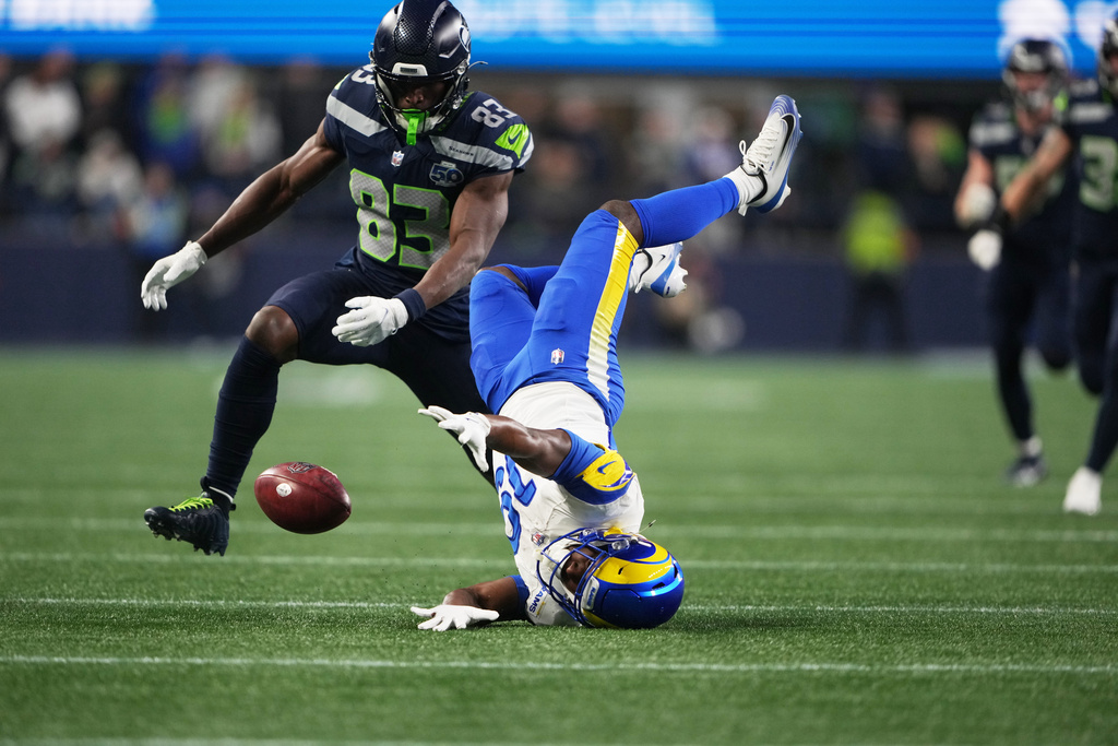 Los Angeles Rams wide receiver Xavier Smith (19) fumbles during a punt return and Seattle Seahawks' Dareke Young (83) recovers the ball during the second half of the NFC Championship NFL football game Sunday, Jan. 25, 2026, in Seattle. (AP Photo/Lindsey Wasson)