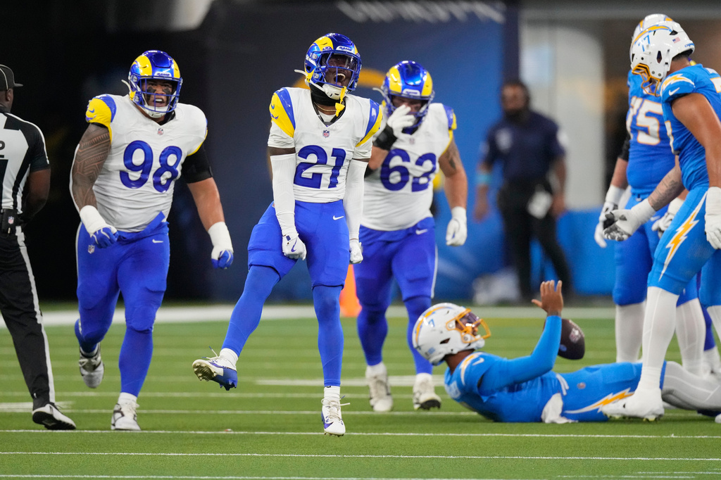 Los Angeles Rams cornerback Cam Lampkin (21) celebrates after bringing down Los Angeles Chargers quarterback DJ Uiagalelei, below, during the first half of an NFL preseason football game Thursday, Aug. 27, 2026, in Inglewood, Calif. (AP Photo/Mark J. Terrill)