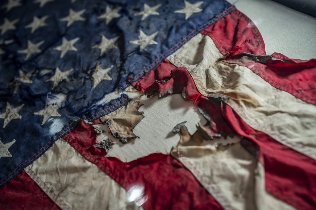 A badly damaged flag recovered from the World Trade Center debris is displayed at the Smithsonian's National Museum of American History, the nation's official repository for September 11 materials, in Washington, Thursday, Sept. 10, 2026. (AP Photo/J. Scott Applewhite)