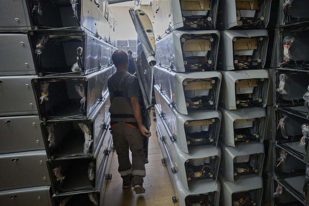 A worker carries part of a combat drone at Fire Point's secret factory in Ukraine on Thursday, Aug. 14, 2025. (AP Photo/Efrem Lukatsky)
