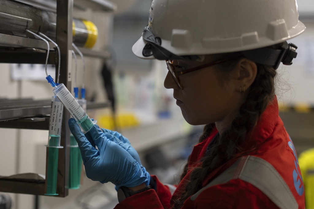 Expedition 501 researcher Alizé Longeau collects water samples from cores aboard the Liftboat Robert platform, in the North Atlantic, in the early morning hours, Sunday, July 20, 2025. (AP Photo/Carolyn Kaster)