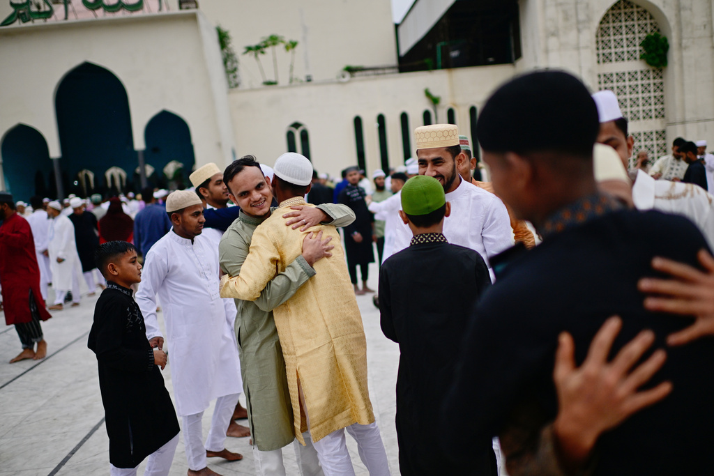 Muslims hug and greet each other after offering Eid al-Fitr prayer marking the end of the holy fasting month of Ramadan at the Baitul Mukarram Mosque in Dhaka, Bangladesh, Saturday, March 21, 2026. (AP Photo/Mahmud Hossain Opu)