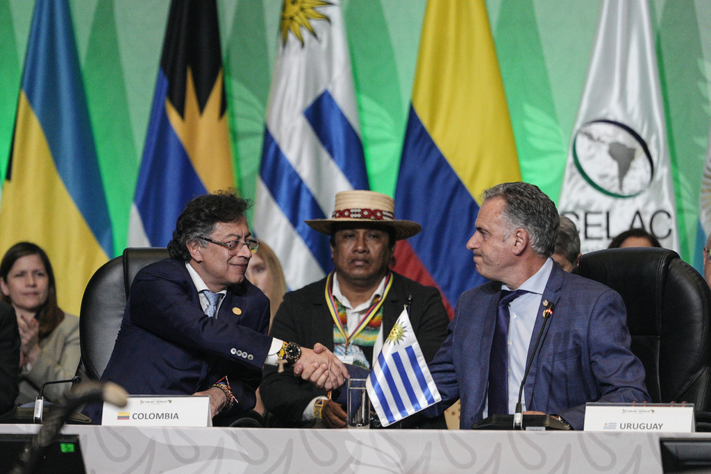 Colombia's President Gustavo Petro, left, shake hands with Uruguayan President Yamandu Orsi, during the summit of the Community of Latin American and Caribbean, or CELAC, in Bogota, Colombia, Saturday, March 21, 2026. (AP Photo/Ivan Valencia)
