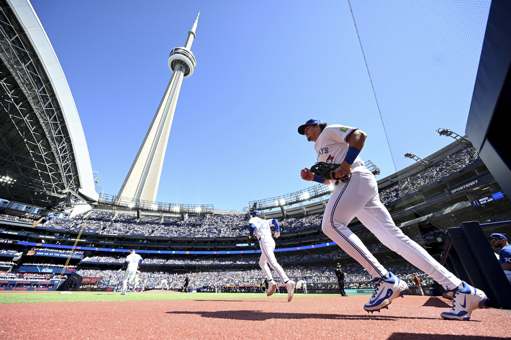 Toronto Blue Jays' Addison Barger, right, and Ernie Clement take to the field prior to the start of a baseball game against the Milwaukee Brewers in Toronto on Sunday, Aug. 31, 2025. (Jon Blacker/The Canadian Press via AP)