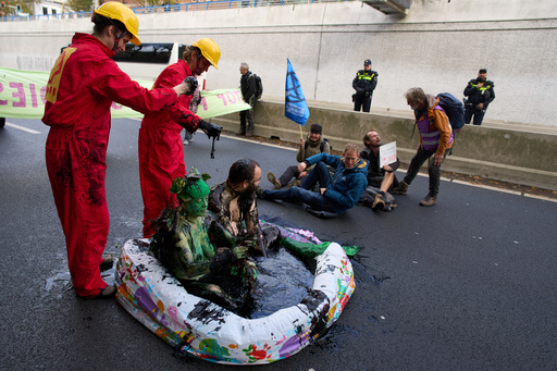 Extinction Rebellion demonstrators, some covered in oil, block a highway to protest fossil subsidies and new fossil fuel projects one day before the Oct. 29 general election, in The Hague, Netherlands, Tuesday, Oct. 28, 2025. (AP Photo/Peter Dejong) Extinction Rebellion demonstrators, some covered in oil, block a highway to protest fossil subsidies and new fossil fuel projects one day before the Oct. 29 general election, in The Hague, Netherlands, Tuesday, Oct. 28, 2025. (AP Photo/Peter Dejong)