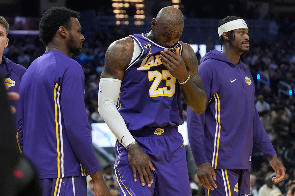 Los Angeles Lakers forward LeBron James (23) walks toward the bench between guard Bronny James, left, and forward Jarred Vanderbilt during the second half of an NBA basketball game against the Golden State Warriors in San Francisco, Thursday, April 9, 2026. (AP Photo/Jeff Chiu)