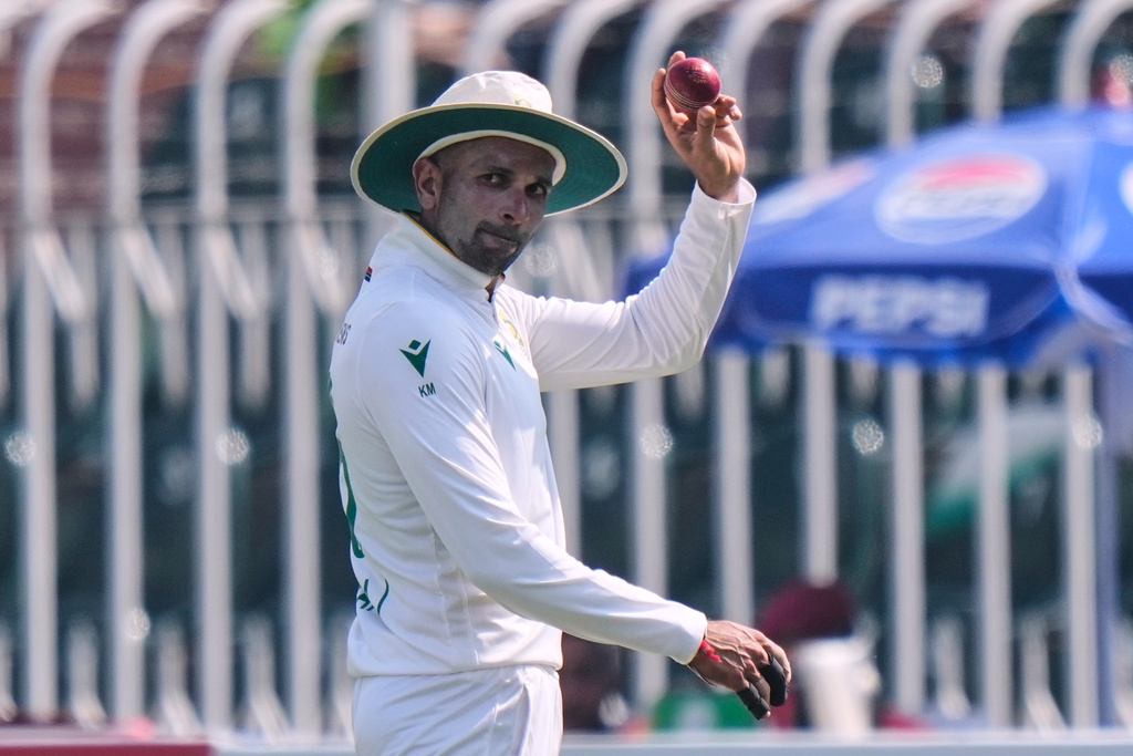South Africa's Keshav Maharaj, who took seven wickets in the first innings, displays the ball during the second day of the second test cricket match between Pakistan and South Africa, at the Rawalpindi Cricket Stadium, in Rawalpindi, Pakistan, Tuesday, Oct. 21, 2025. (AP Photo/Anjum Naveed)