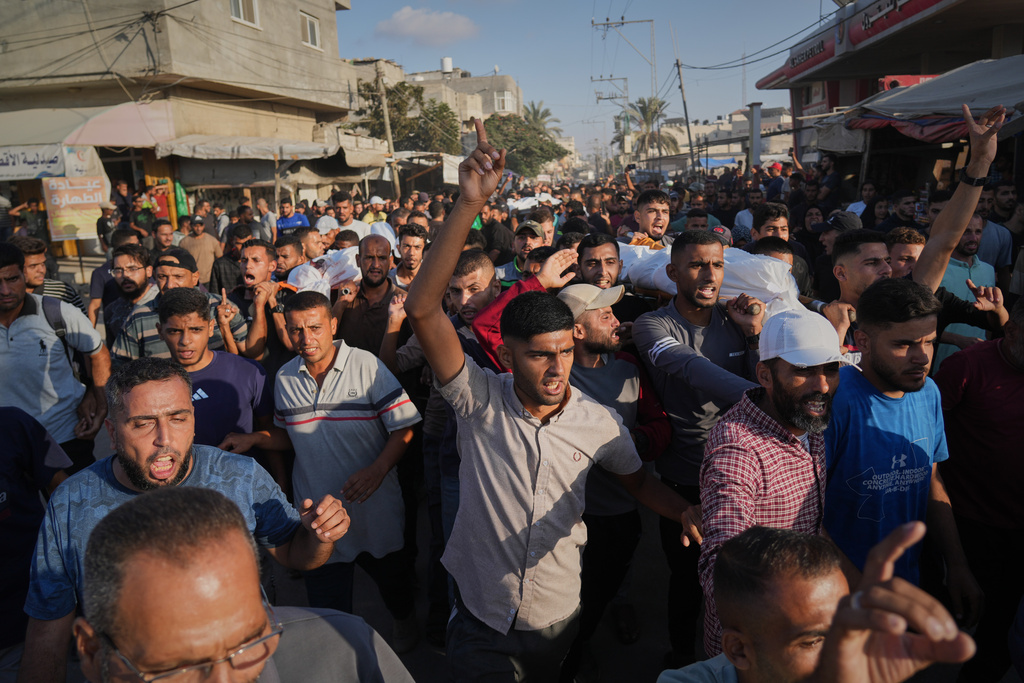 Mourners carry bodies of Palestinians killed by Israeli fire, during their funeral in Deir al-Balah, Gaza Strip, Sunday, Oct. 19, 2025. (AP Photo/Abdel Kareem Hana)
