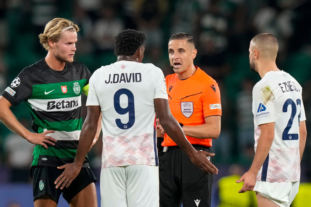 FILE - Referee Donatas Rumsas, second right, discusses with Lille's Jonathan David during the Champions League opening phase soccer match between Sporting CP and Lille at the Alvalade stadium in Lisbon, Sept. 17, 2024. (AP Photo/Armando Franca, File)
