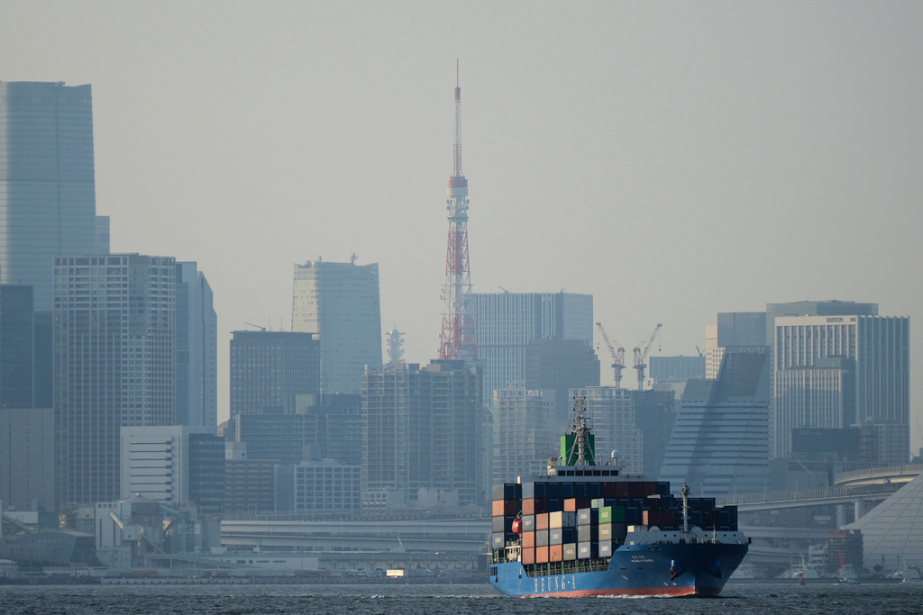FILE -Tokyo Tower is seen amid tall buildings as a container ship leaves a cargo terminal in Tokyo, Wednesday, April 9, 2025. (AP Photo/Hiro Komae, File)
