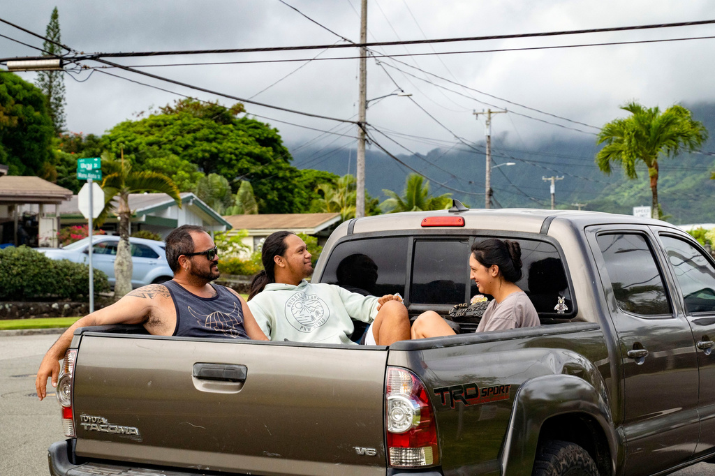 Kimeona Kane rides with his nephew, Gabriel Shimaoka, and niece, Genesis Shimaoka, in the bed of his pickup truck, Friday, July 17, 2026, in Kailua, Hawaii. (AP Photo/Mengshin Lin)