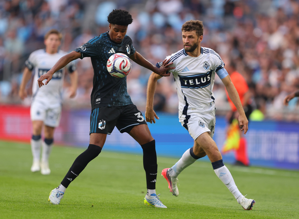 Minnesota United FC midfield Owen Gene (30) pushes Vancouver Whitecaps FC midfield Thomas Müller (13) during the first half of an MLS soccer match on Saturday, July 25, 2026, in St. Paul, Minn. (AP Photo/Adam Bettcher)