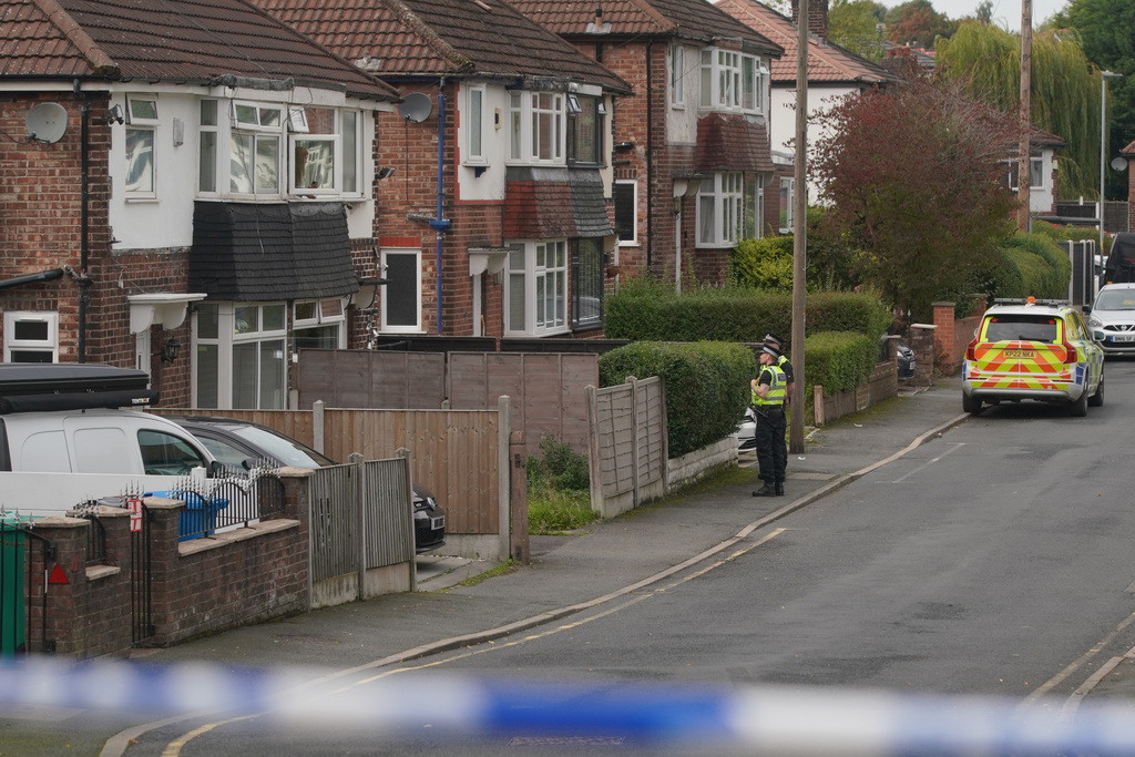 Police speak to a local resident close to the scene of a stabbing incident at Heaton Park Hebrew Congregation synagogue, in Crumpsall, Manchester, England, Thursday, Oct. 2, 2025. (AP Photo/Ian Hodgson)