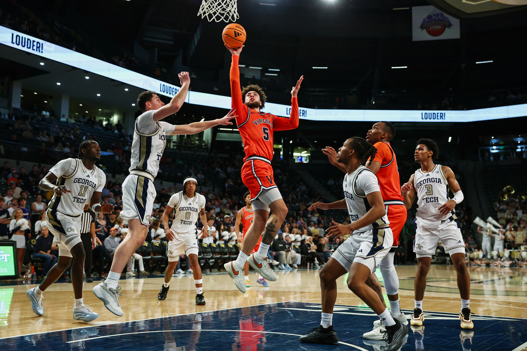 Virginia guard Sam Lewis (5) shoots against Georgia Tech guards Kam Craft, left, and Lamar Washington, right, during the first half of an NCAA college basketball game, Wednesday, Feb. 18, 2026, in Atlanta. (AP Photo/Colin Hubbard)