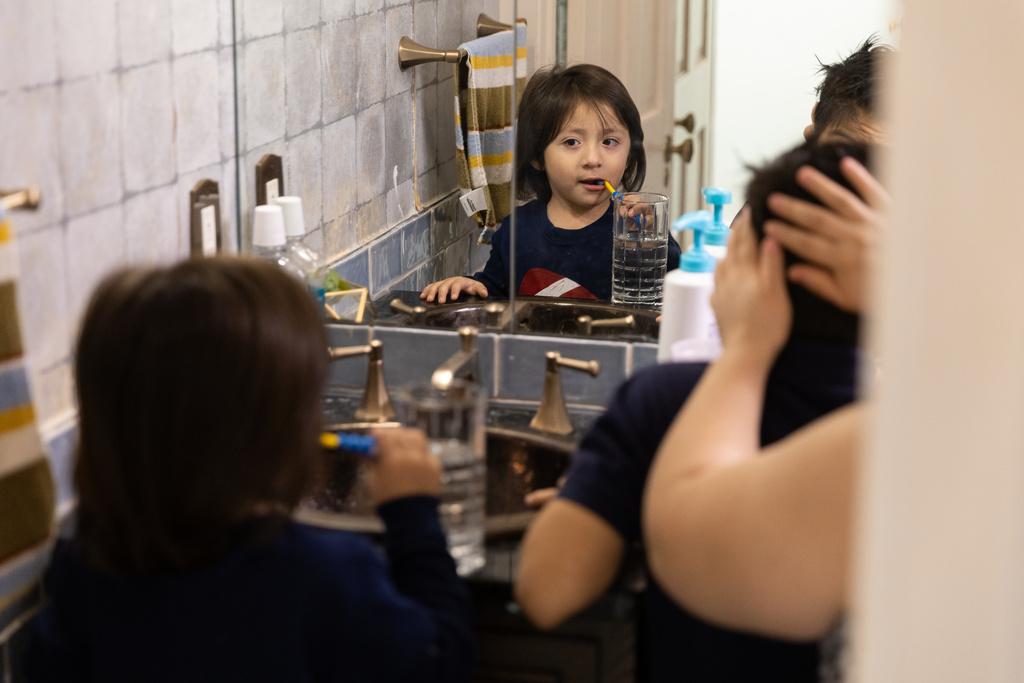 Yair, 3, left, and Giancarlo, 10, get ready with the help of their mom Tuesday, Feb. 3, 2026, in Minneapolis. (AP Photo/Liam James Doyle)
