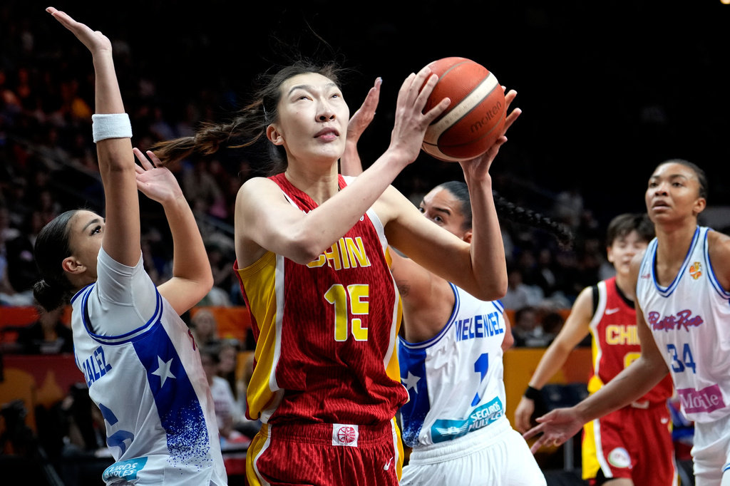 China's Han Xu, center, plays the ball during the Women's Basketball World Cup qualification playoff between Puerto Rico and China in Berlin, Wednesday, Sept. 9, 2026. (AP Photo/Ebrahim Noroozi)