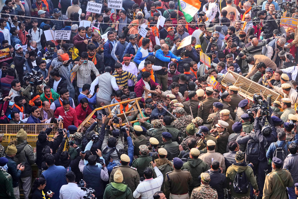Police officers try to stop activists of Vishwa Hindu Parishad, a prominent right-wing Hindu nationalist organization, crossing over barricades during a protest near Bangladesh High Commission accusing Bangladeshi groups of wrongly targeting Indians, in New Delhi, India, Tuesday, Dec. 23, 2025. (AP Photo/Manish Swarup)