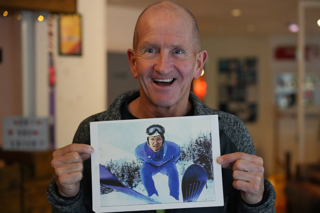 British former ski jumper Michael Edwards, known as Eddie the Eagle, displays one of his first ever taken press photos during an interview at the Ski and Snowboard Center, in Gloucester, England, Wednesday, Nov. 19, 2025. (AP Photo/Frank Augstein)
