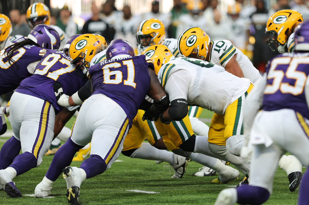 Minnesota Vikings' Domonique Orange (97) and Jalen Redmond (61) help stop Green Bay Packers quarterback Jordan Love (10) from running the ball for a first down during the second half of an NFL football game, Sunday, Sept. 13, 2026, in Minneapolis, Minn. (AP Photo/Bailey Hillesheim)