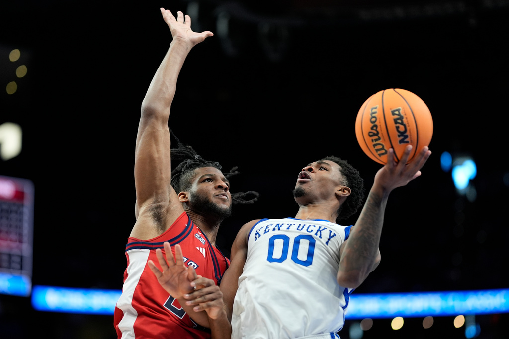 Kentucky guard Otega Oweh (00) shoots against St. John's forward Zuby Ejiofor (24) during the first half of an NCAA basketball game, Saturday, Dec. 20, 2025, in Atlanta. (AP Photo/Mike Stewart)