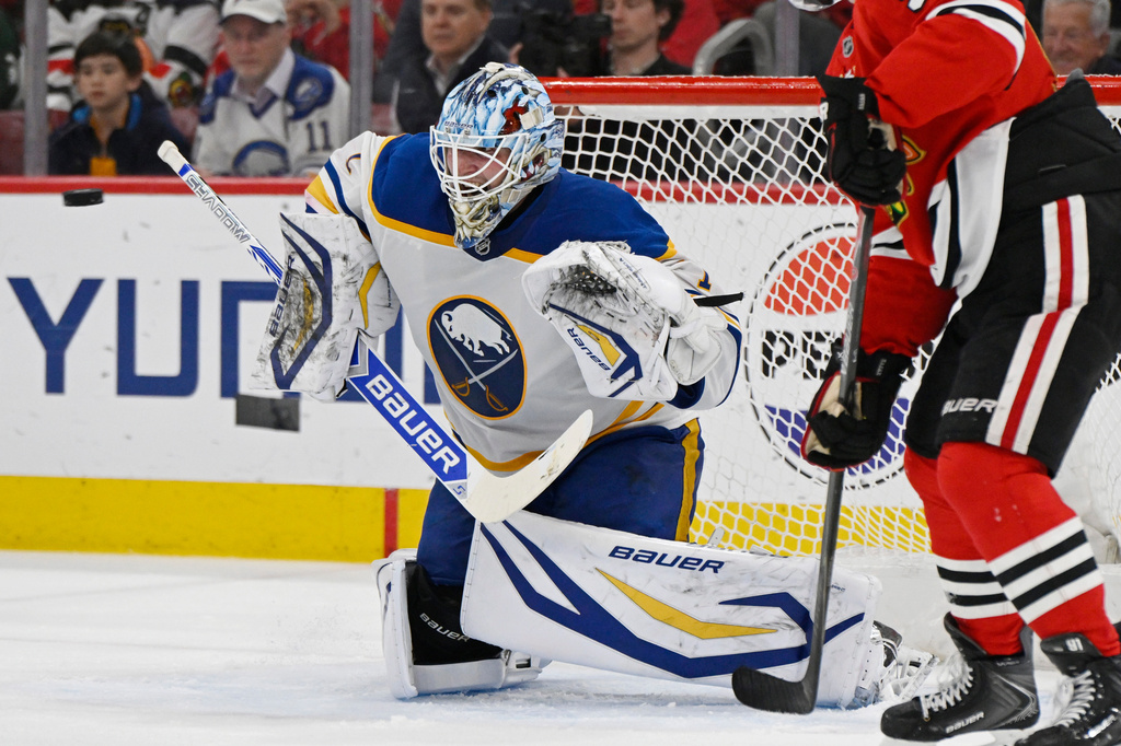 Buffalo Sabres goalie Ukko-Pekka Luukkonen, left, makes a save during the second period of an NHL hockey game against the Chicago Blackhawks in Chicago, Monday, April 13, 2026. (AP Photo/Paul Beaty)