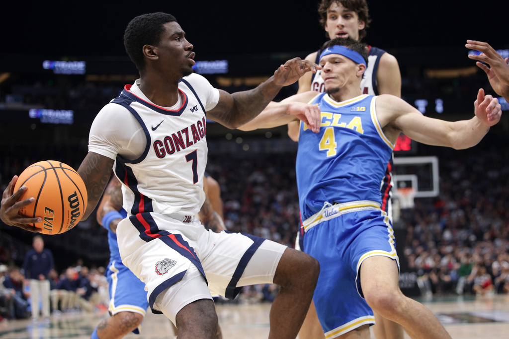Gonzaga guard Tyon Grant Foster (7) moves the ball as UCLA guard Jamar Brown (4) defends during the first half of a NCAA basketball game, Saturday, Dec. 13, 2025, in Seattle. (AP Photo/Jason Redmond)