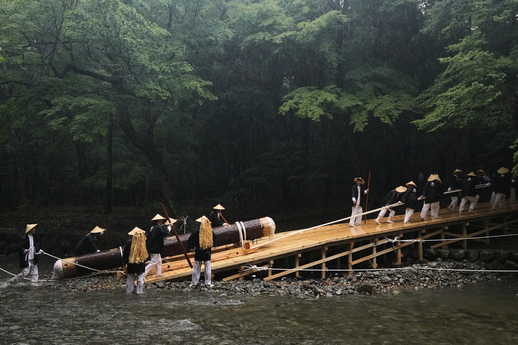 People pull a sacred timber up from a creek, carrying into the Kotaijingu, also known as Naiku, or the inner sanctuary, of the Ise Jingu shrine complex during the Mihishirogi Hoeishiki ceremony of the Shikinen Sengu ritual to rebuild its main structures for Shinto deities, in Ise, central Japan, June 9, 2025. (AP Photo/Hiro Komae)