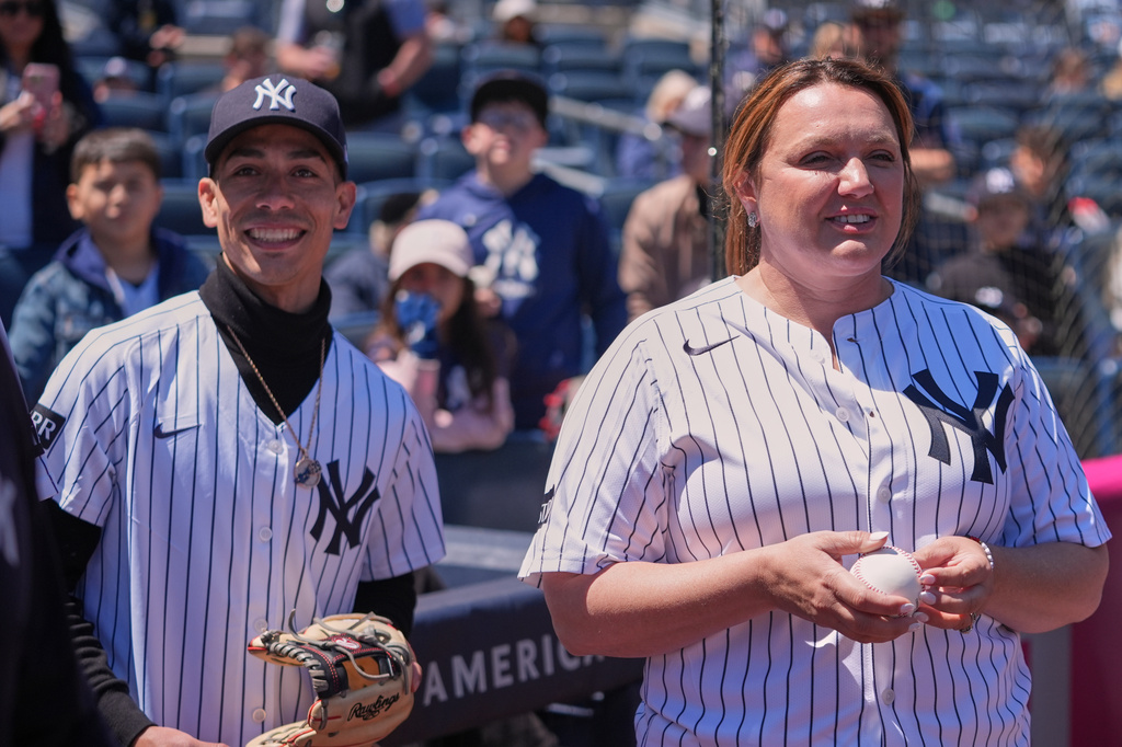 Golden Tempo trainer Cherie DeVaux, right, and jockey Jose Ortiz wait to throw out a ceremonial first pitch before a baseball game between the New York Yankees and the Texas Rangers Thursday, May 7, 2026, in New York. (AP Photo/Frank Franklin II)