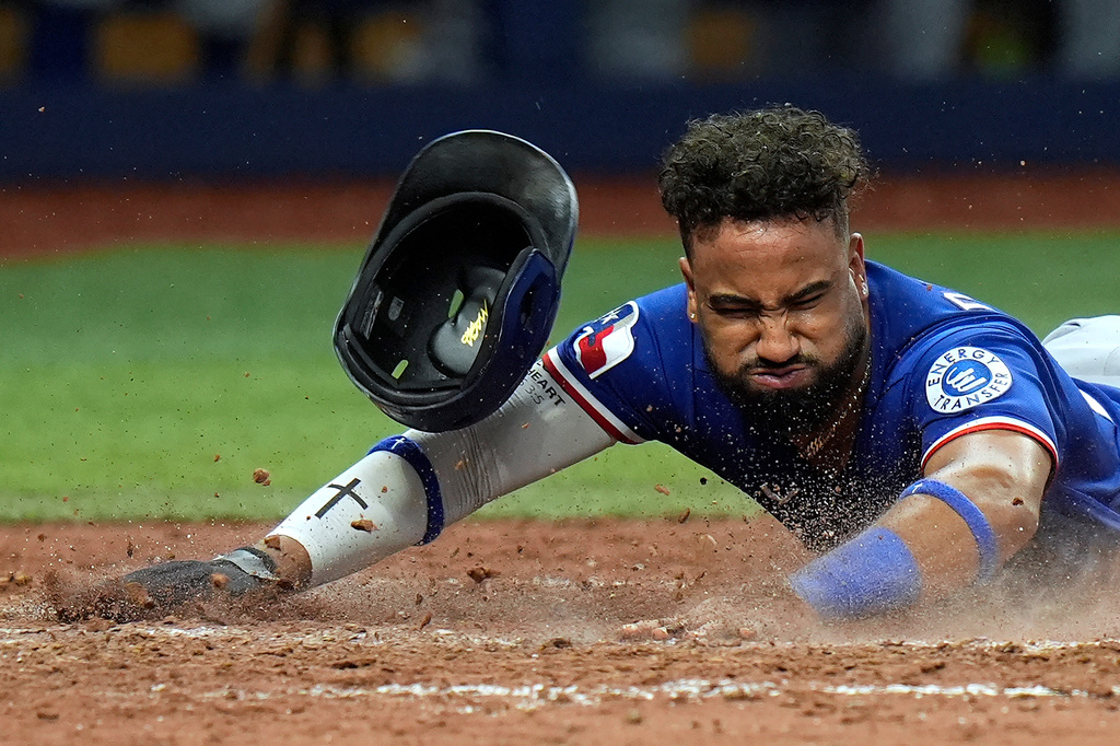Texas Rangers' Ezequiel Duran loses his helmet after scoring on an RBI single by Evan Carter off Tampa Bay Rays pitcher Craig Kimbrel during the eighth inning of a baseball game Tuesday, July 28, 2026, in St. Petersburg, Fla. (AP Photo/Chris O'Meara)