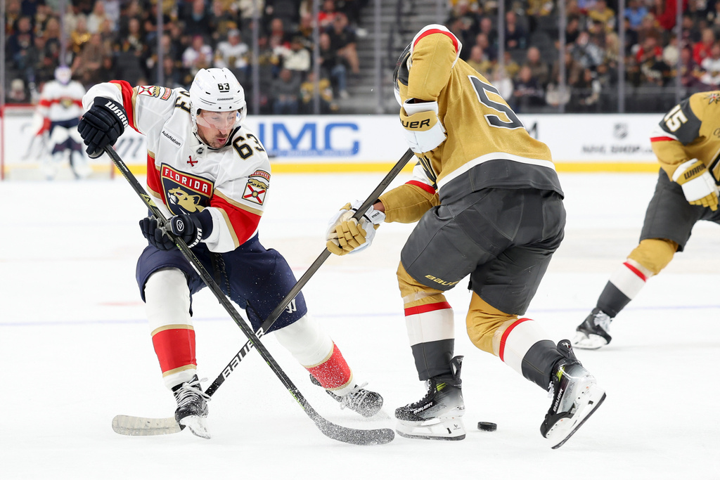 Florida Panthers left wing Brad Marchand (63) skates against Vegas Golden Knights right wing Keegan Kolesar, center right, during the first period of an NHL hockey game Monday, Nov. 10, 2025, in Las Vegas. (AP Photo/Ian Maule)