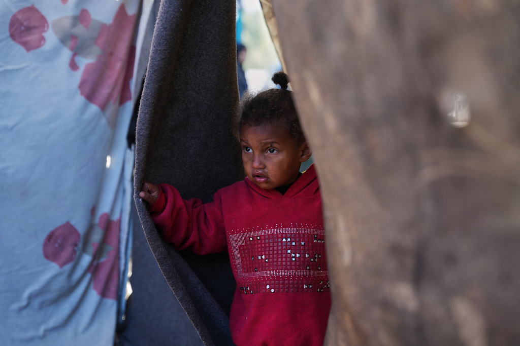2-year-old Sidra Obeid looks on as she stands in her family's tent in a makeshift camp for displaced Palestinians in Deir al-Balah, central Gaza Strip, Saturday, Dec. 27, 2025. (AP Photo/Abdel Kareem Hana)