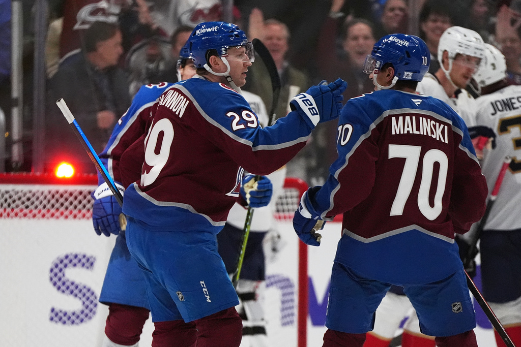 Colorado Avalanche defenseman Sam Malinski, right, congratulates center Nathan MacKinnon after his goal agains the Florida Panthers in the second period of an NHL hockey game Thursday, Dec. 11, 2025, in Denver. (AP Photo/David Zalubowski)