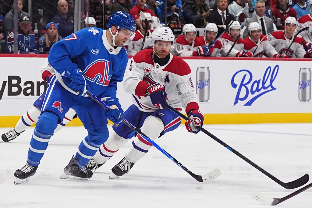 Colorado Avalanche defenseman Devon Toews, left, steals puck from Montreal Canadiens defenseman Mike Matheson in the second period of an NHL hockey game Saturday, Nov. 29, 2025, in Denver. (AP Photo/David Zalubowski)