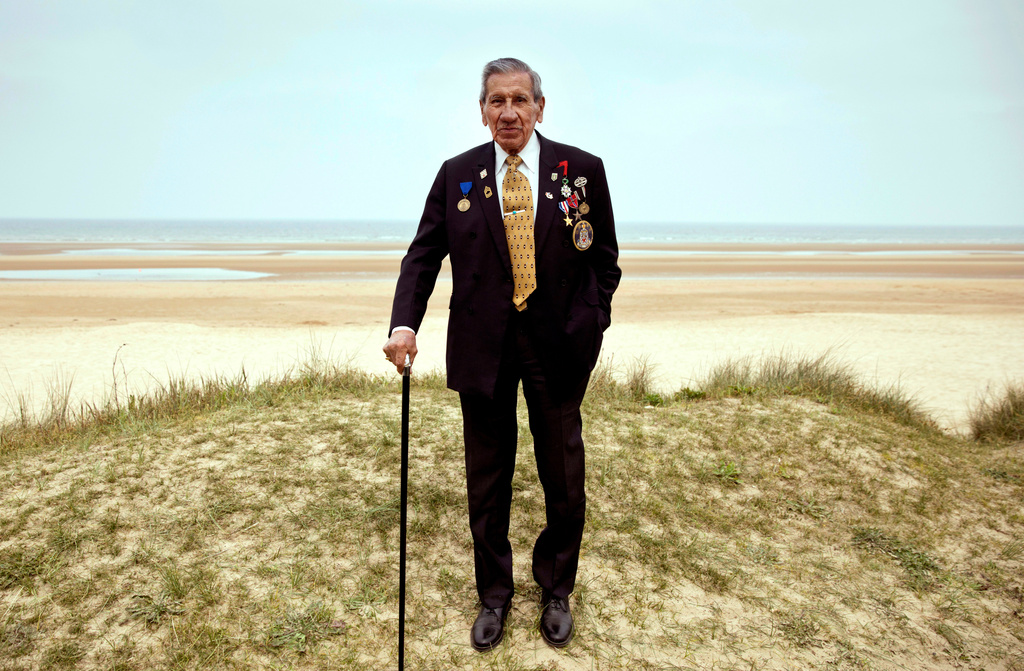 FILE - In this Wednesday, May 1, 2019 file photo, World War II and D-Day veteran Charles Norman Shay, from Maine, poses at the Charles Shay monument on Omaha Beach in Normandy, France. Instead of parades, remembrances, embraces and one last great hurrah for veteran soldiers who are mostly in their nineties to celebrate VE Day, it is instead a lockdown due to the coronavirus, COVID-19. (AP Photo/Virginia Mayo, File)