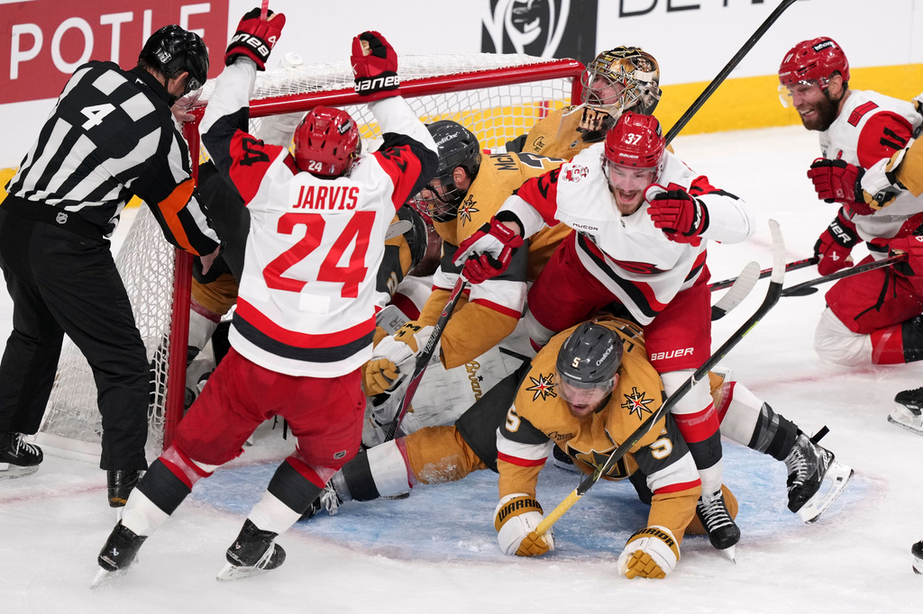 Carolina Hurricanes right wing Andrei Svechnikov (37) celebrates his goal with right wing Seth Jarvis (24) and center Jordan Staal (11) as he steps over Vegas Golden Knights defenseman Jeremy Lauzon (5) during the third period in Game 3 of the NHL hockey Stanley Cup Final series Saturday, June 6, 2026, in Las Vegas. (AP Photo/Candice Ward)