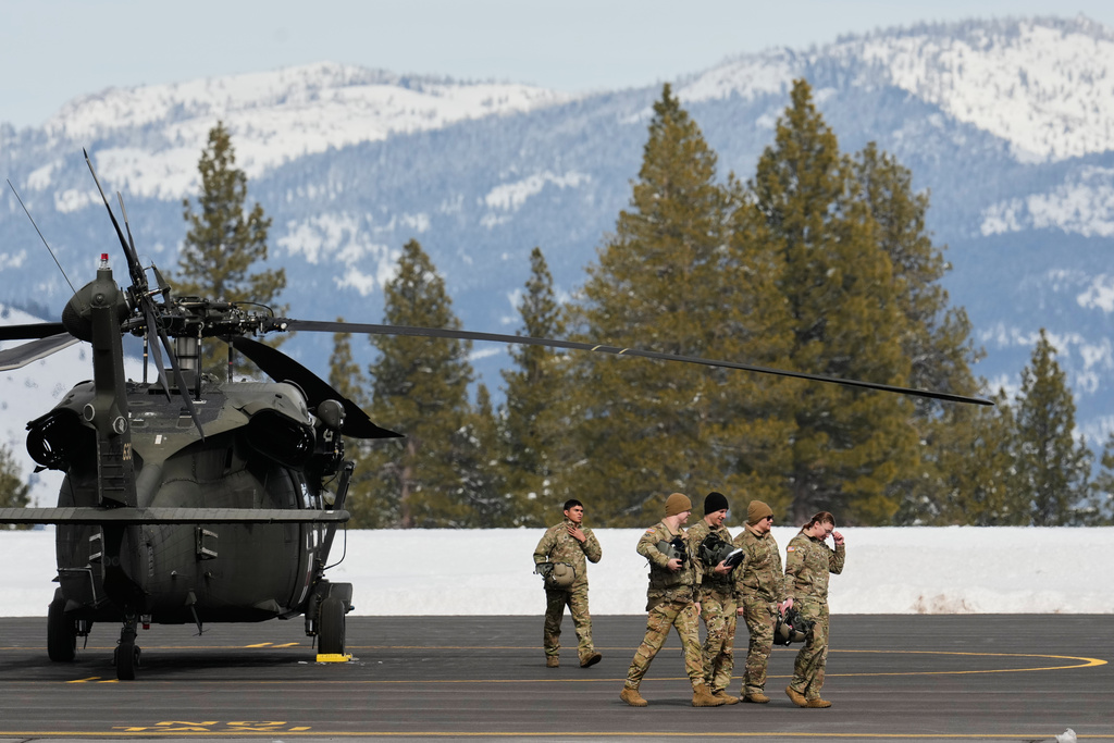 U.S. Army soldiers exit a Black Hawk at the Truckee Tahoe Airport in Truckee, Calif., Saturday, Feb. 21, 2026, after aiding in recovery efforts for a group of skiers who went missing during a deadly avalanche. (AP Photo/Godofredo A. Vásquez)