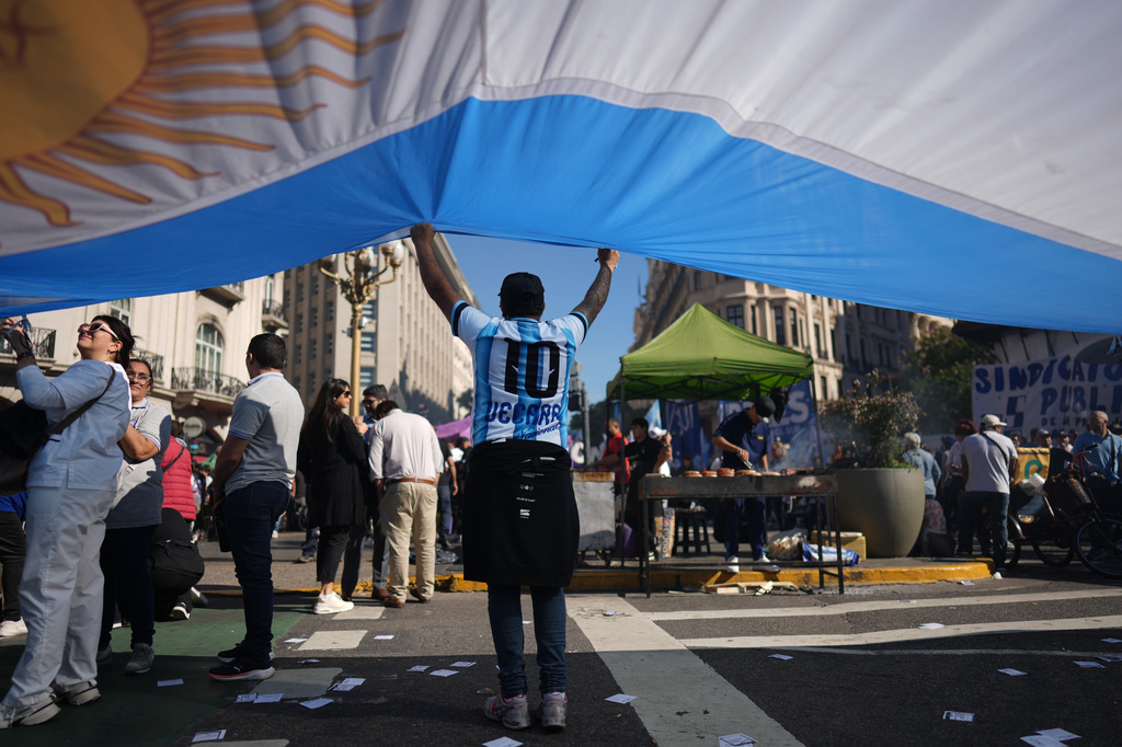 A laborer holds an Argentine flag during a May Day demonstration in Buenos Aires, Argentina, Thursday, April 30, 2026. (AP Photo/Rodrigo Abd)