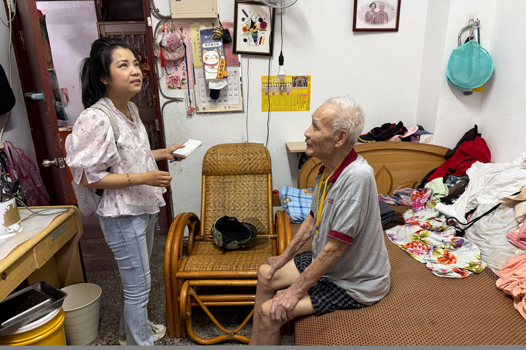 Shang Guan, a writer and activist from China who moved to Taiwan in 2021, visits 97 years old military veteran Li Guo-dong, right, in Taipei, Taiwan, on July 20, 2026. (AP Photo/Johnson Lai)